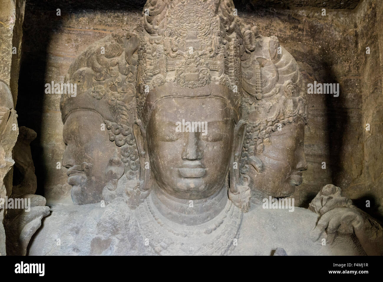 The 3 faces of Shiva inside the main cave on Elephanta Island, carved out of solid rocks Stock Photo