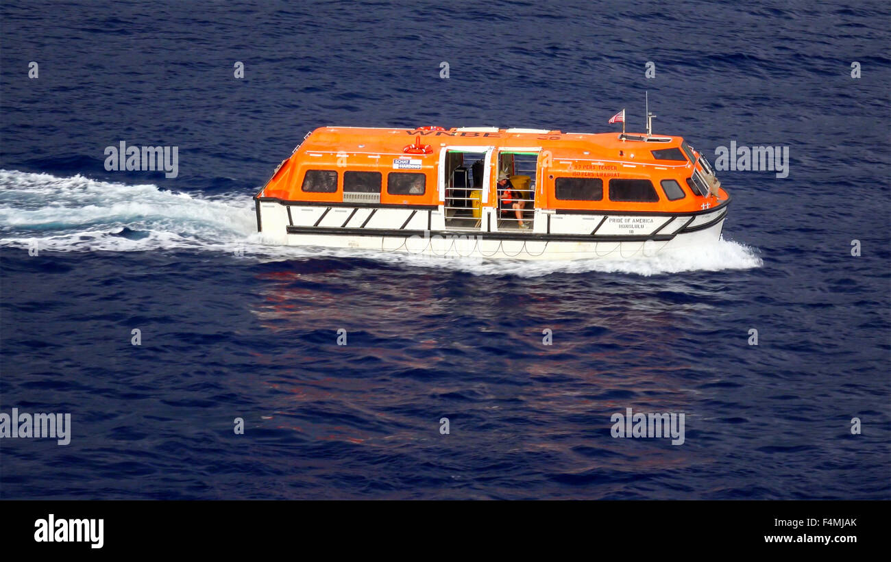 A cruise ship tender aka lifeboat returning to the ship full of tourists on Hawaii Stock Photo
