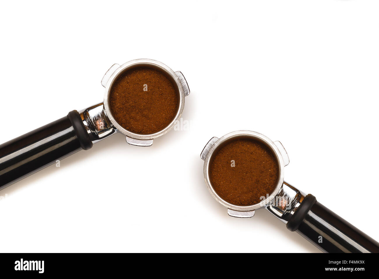 Two italian espresso coffee machine pistons. With ground coffee isolated on white background. Stock Photo