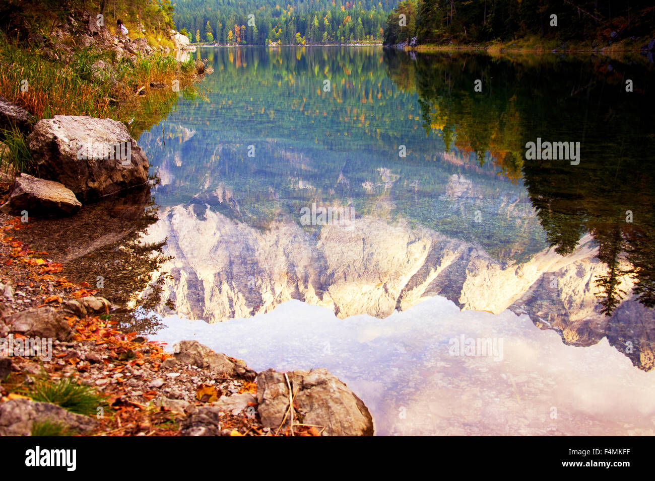 The peak of a high mountain reflected in a calm lake at the foot of the Bavarian Alps. Photo shot in fall, late in the afternoon Stock Photo