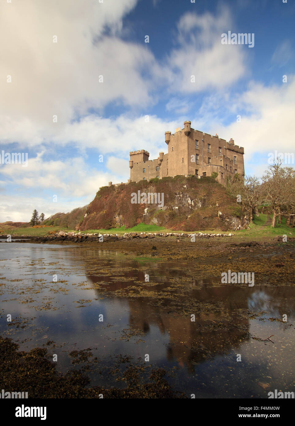 Reflections of Dunvegan Castle in Loch Dunvegan on a sunny day Stock Photo