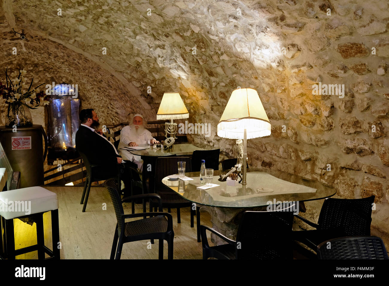 Religious Jews siting inside the 'Between the Arches' Kosher restaurant in el Wad or Hagai street in the Muslim Quarter old city East Jerusalem Israel Stock Photo