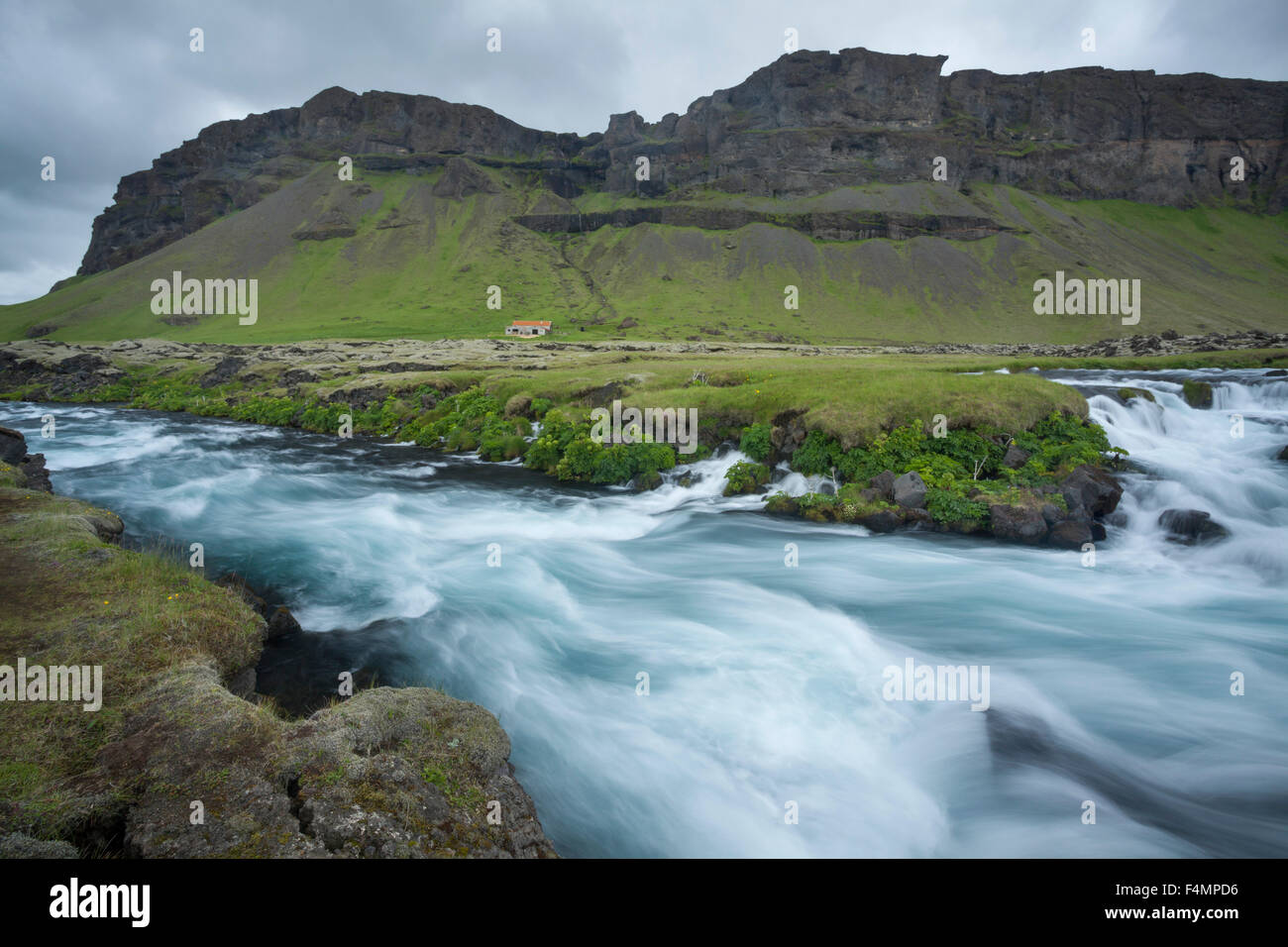 Cliffs and farmhouse beside the Odulbruara river, Brunasandur, Sudhurland, Iceland. Stock Photo