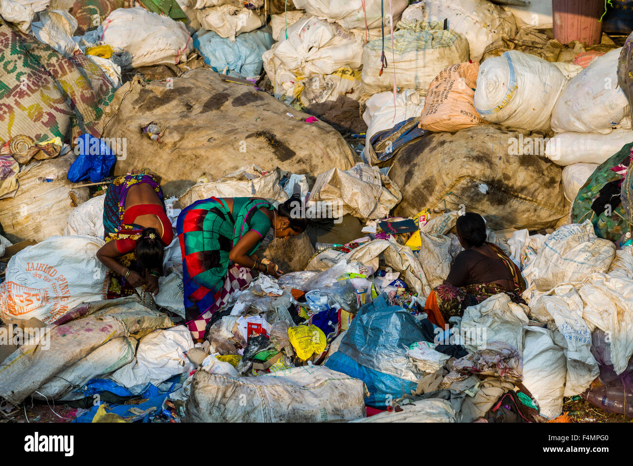Two women in colorful saris are sorting out garbage. About 10.000 labour are working in 800 little companies, mainly in the garb Stock Photo