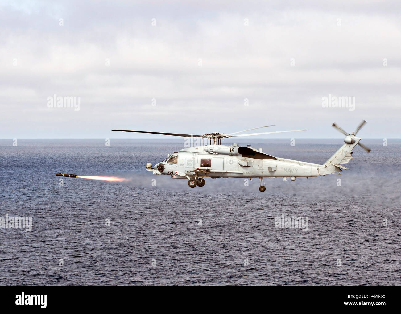 US Navy MH-60R Sea Hawk helicopter fires an AGM-114 Hellfire missile during a training exercise October 14, 2015 in the Pacific Ocean. Stock Photo