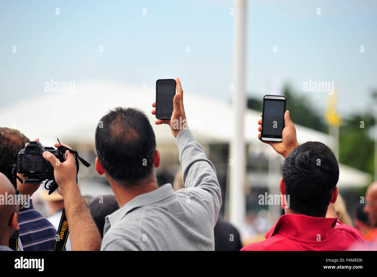 The crowd use cameras and smartphones to take photos at the Goodwood Festival of Speed in the UK. Stock Photo