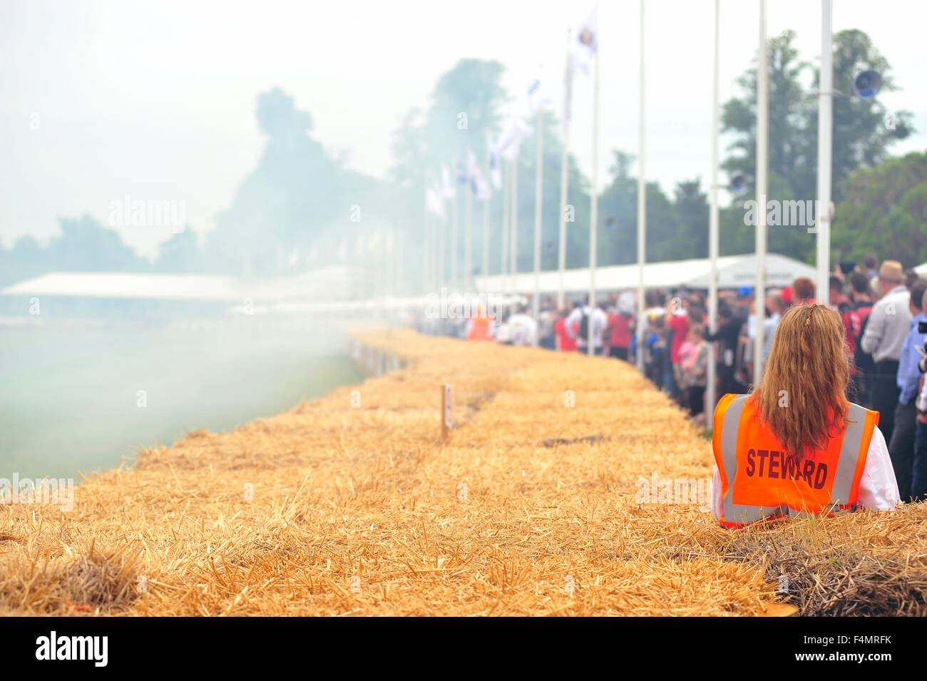 A woman in an orange Steward bib at the Goodwood Festival of Speed in the UK. Stock Photo