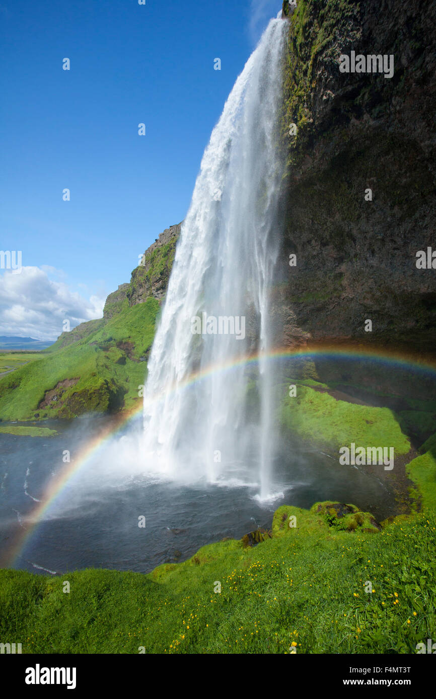 Rainbow beneath 60m-high Seljalandsfoss waterfall, Sudhurland, Iceland. Stock Photo