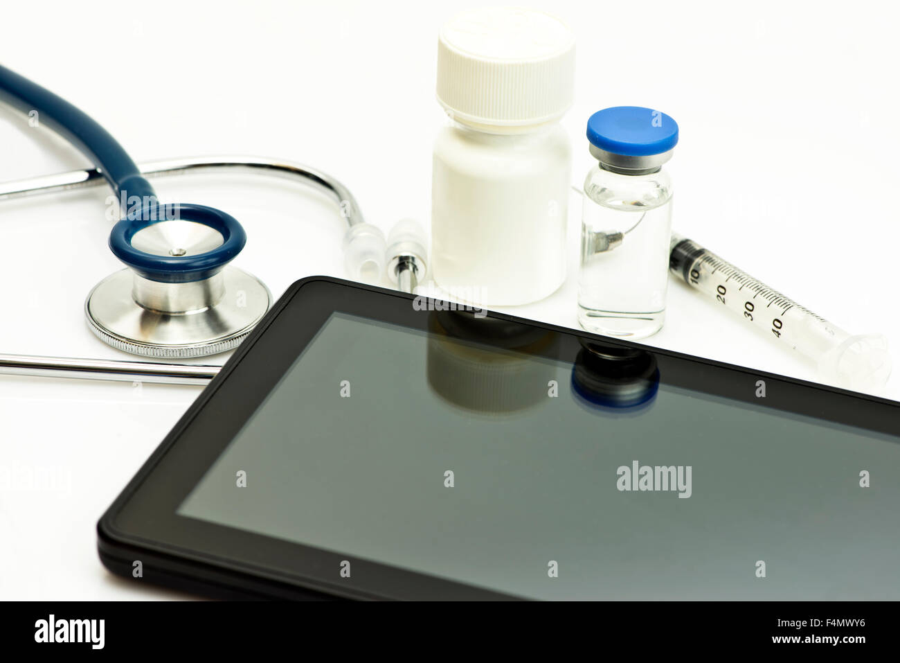 Personal computing device with stethoscope and medications. Stock Photo