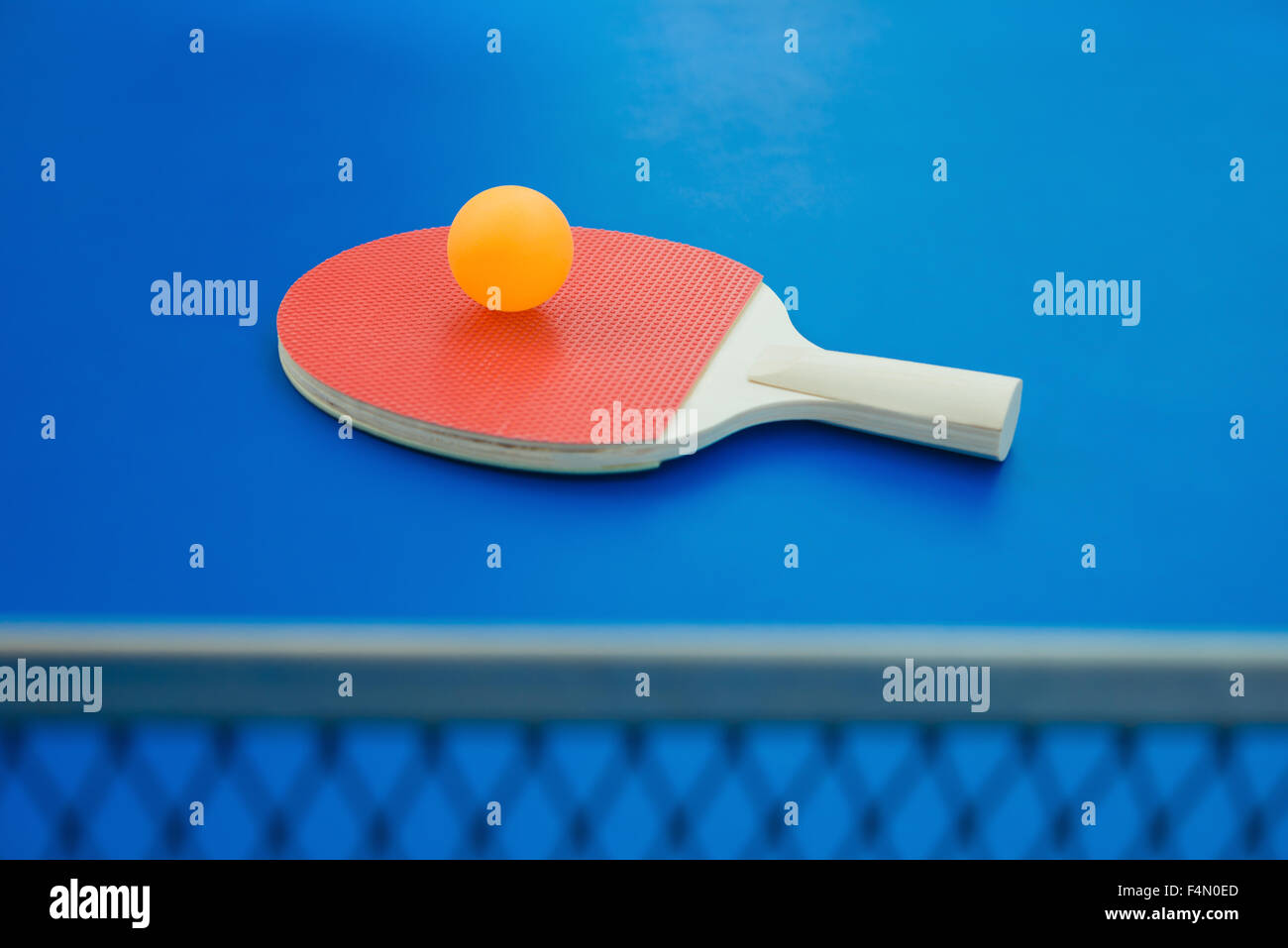 pingpong racket and ball and net on a blue pingpong table Stock Photo