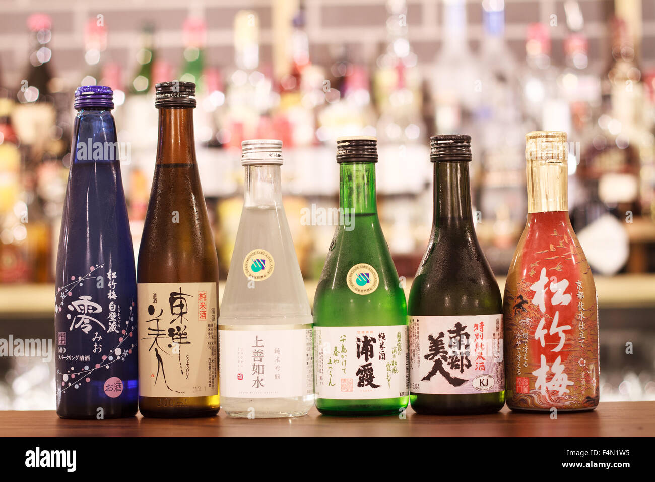 A row of small Japanese Saki bottles on a bar top Stock Photo