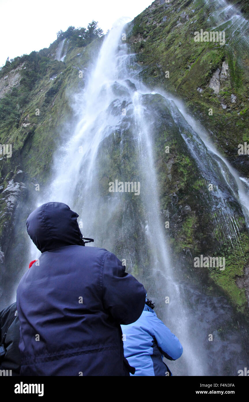 Tourist photographing Stirling Falls, Milford Sound, Fiordland, New Zealand Stock Photo