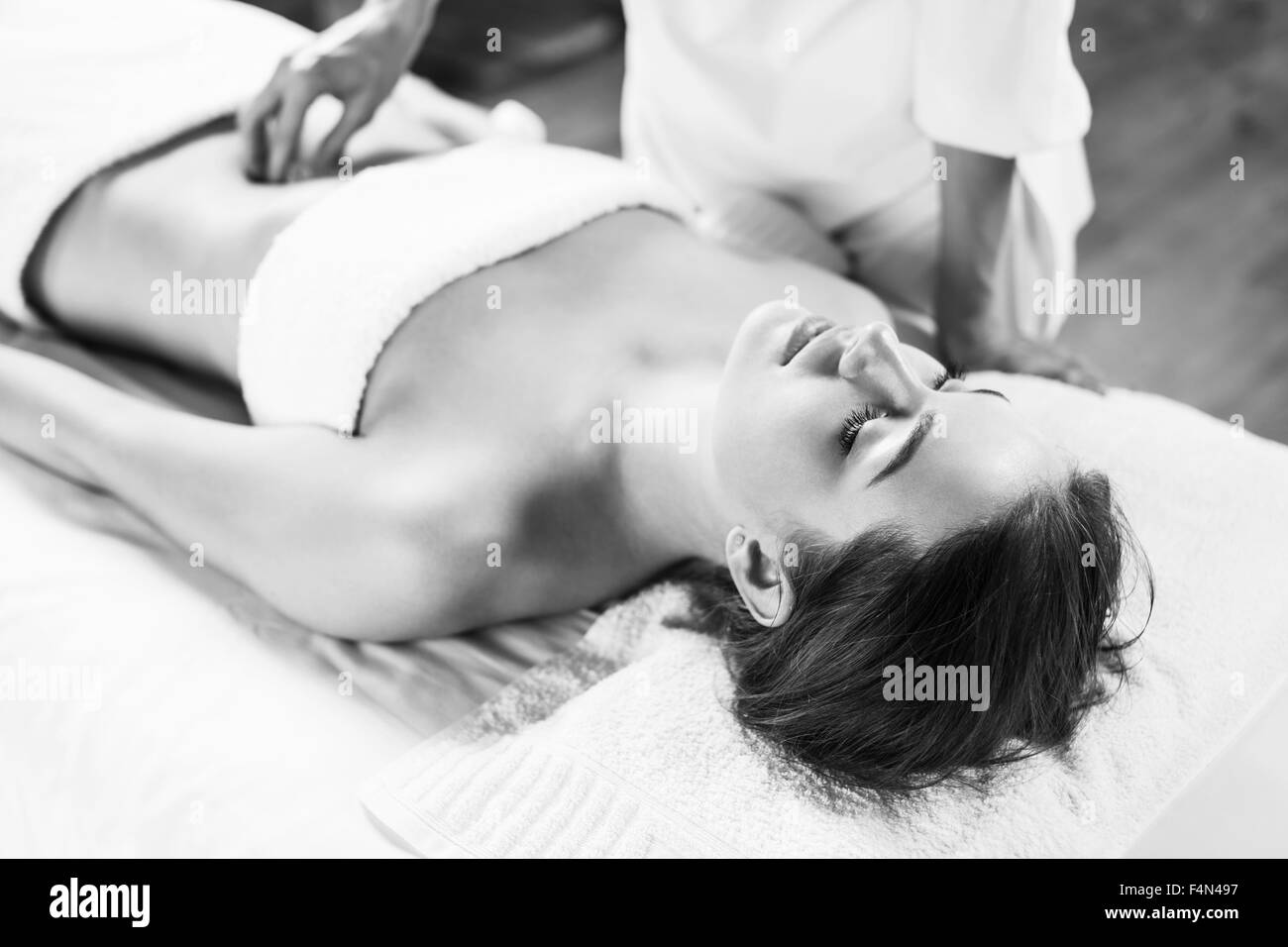 Woman enjoys massage of tummy at the health spa Stock Photo