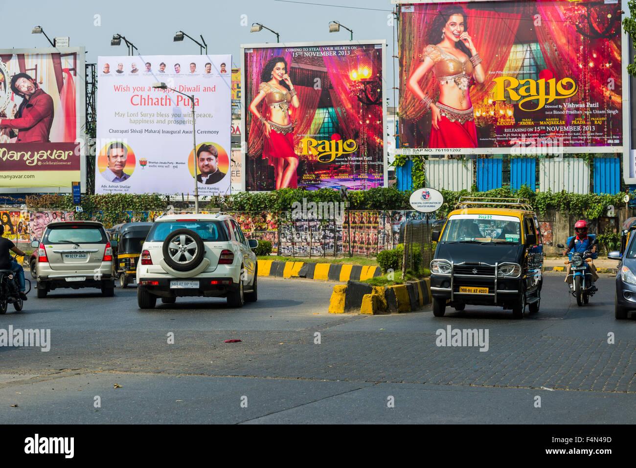 Big commercial advertisements and some cars at a main road in the suburb Juhu Stock Photo