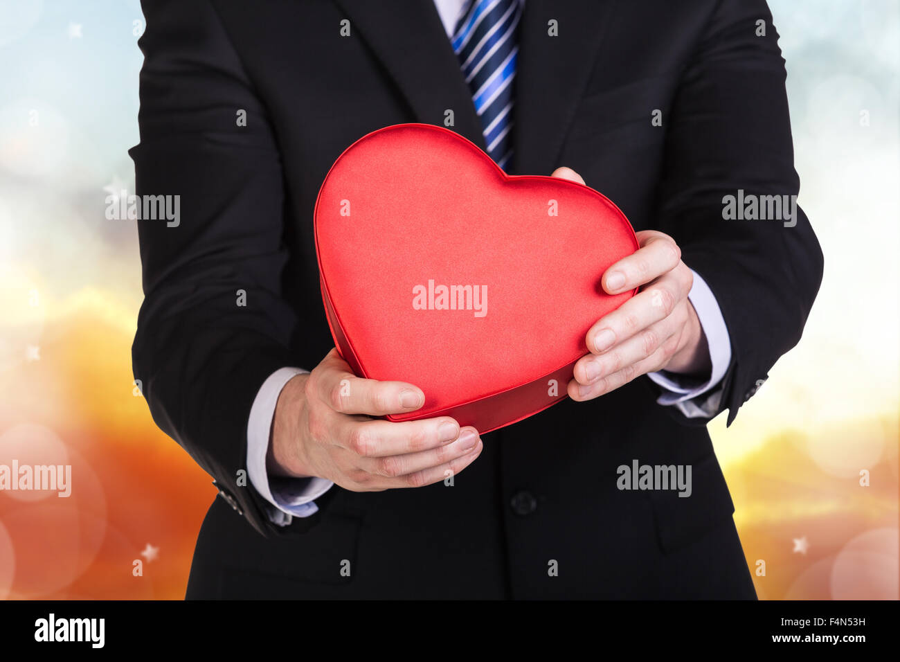 Young man holds red heart box Stock Photo - Alamy