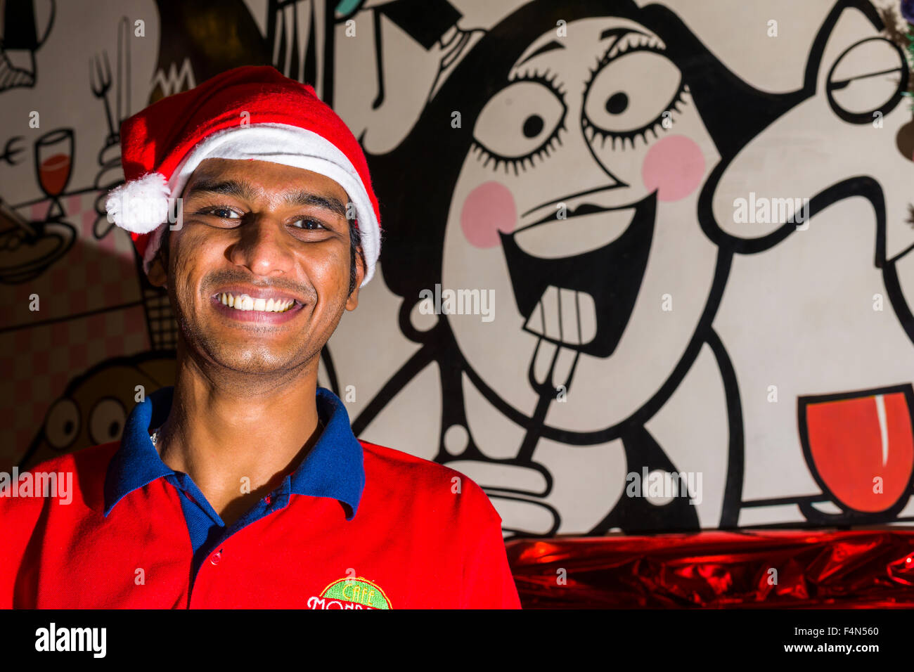 A waiter is wearing a Santa Claus hat at Christmas in a tourist restaurant in the suburb Colaba Stock Photo