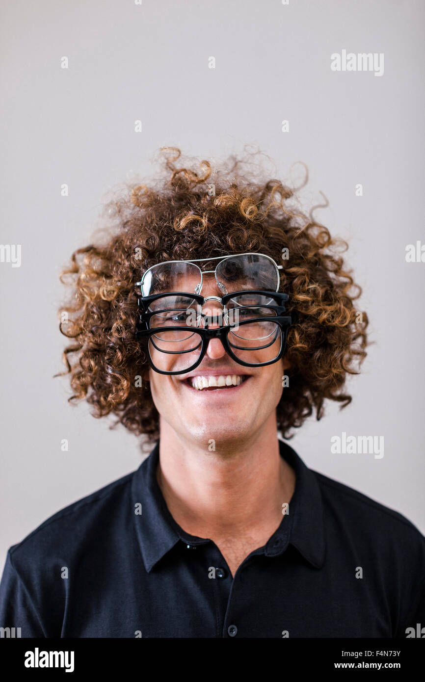 portrait-of-smiling-man-with-curly-hair-wearing-four-different-glasses