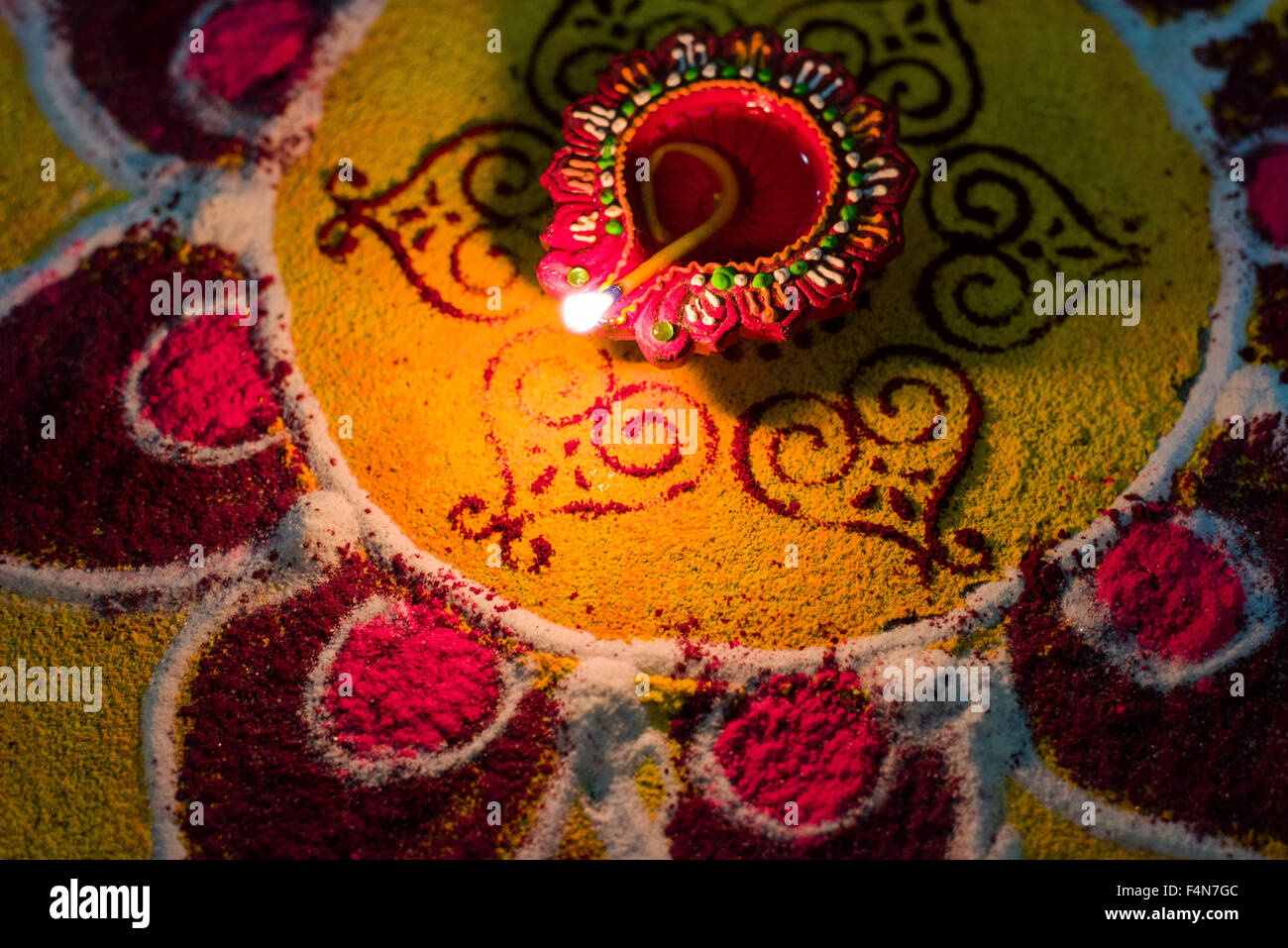 The Rangoli, an artwork made from colorpowder and an oil lamp to welcome the festival Diwali Stock Photo