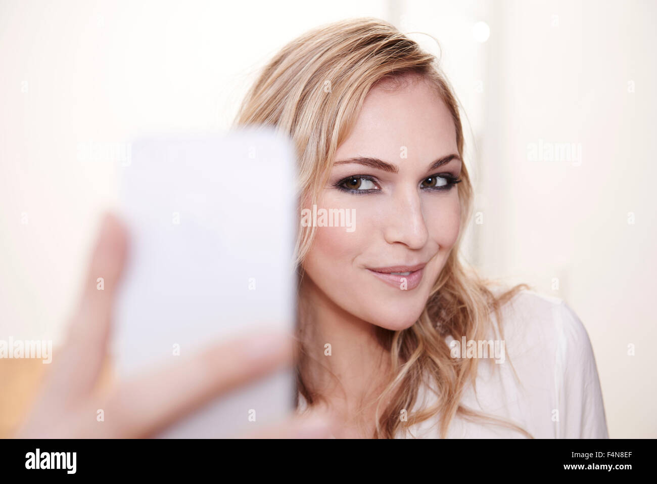 Smiling young woman taking selfie Stock Photo - Alamy