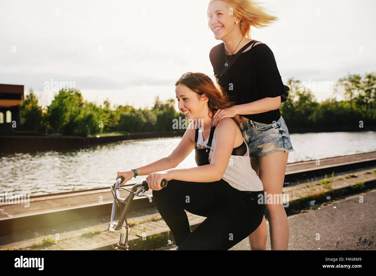 Two friends riding BMX bicycle together Stock Photo