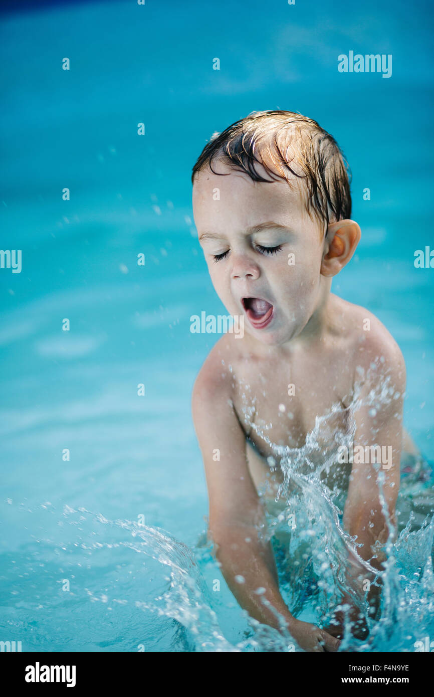 Little boy splashing in a paddling pool Stock Photo Alamy