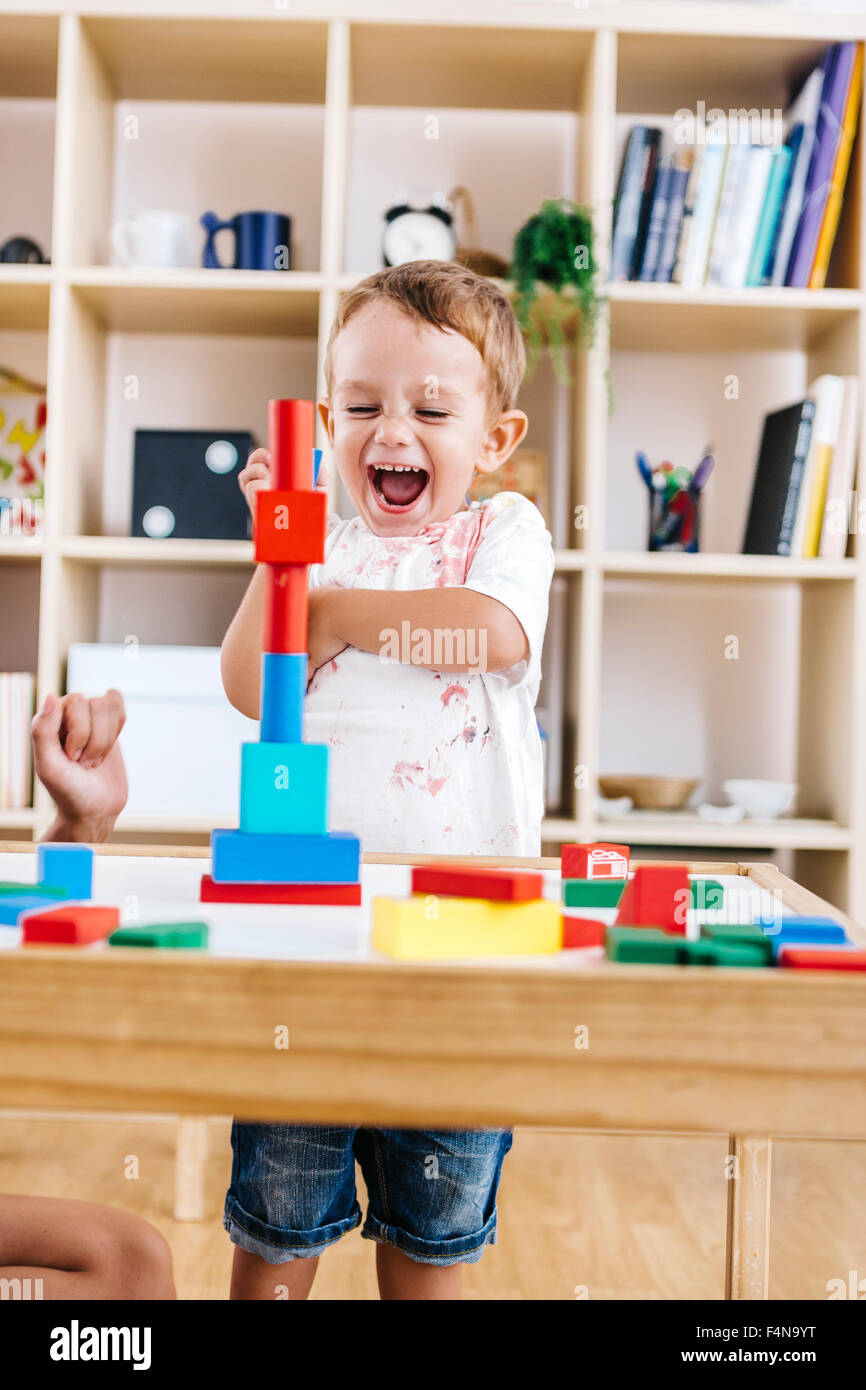 Portrait of excited little boy playing with building bricks Stock Photo