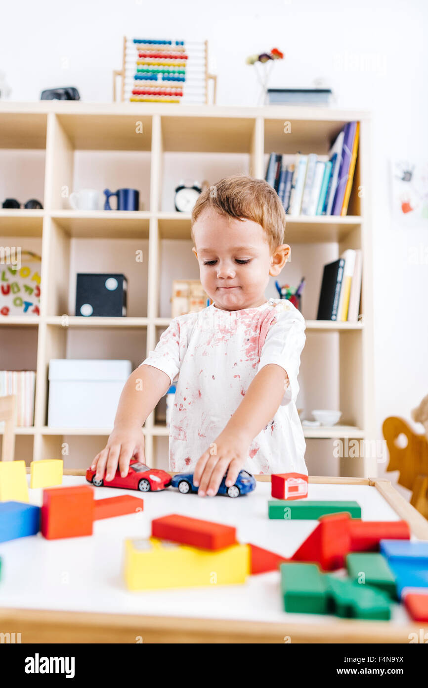Portrait of little boy playing with toy cars Stock Photo - Alamy
