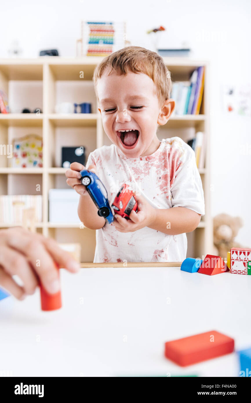 Portrait of laughing little boy playing with toy cars Stock Photo Alamy