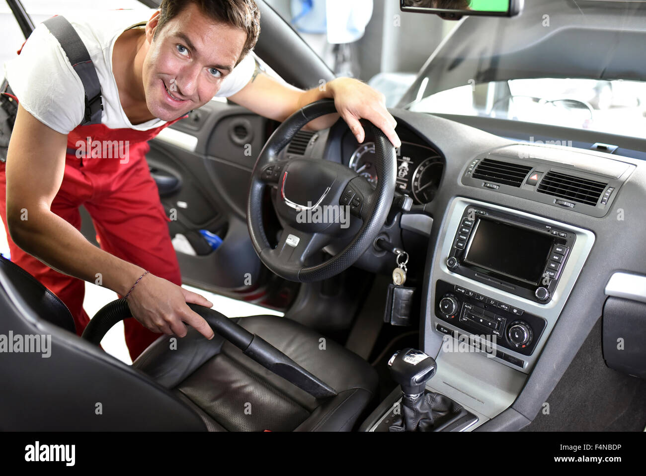 Car cleaning, man hoovering car interior Stock Photo