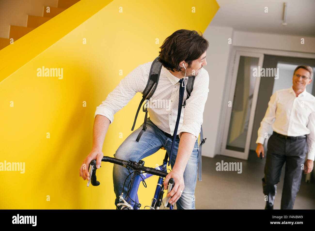 Man with racing bicycle in an office Stock Photo