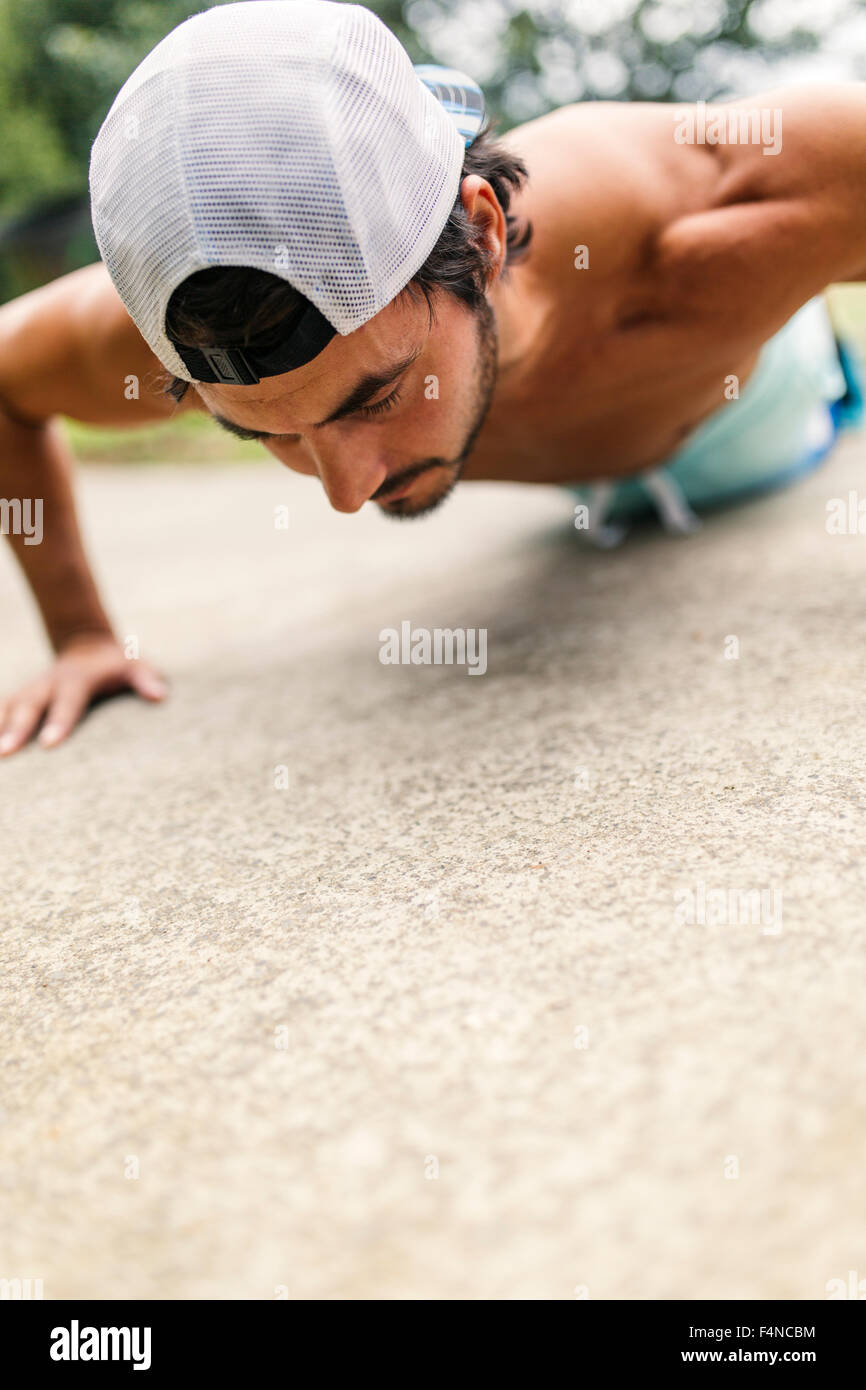 Young man doing push ups in park Stock Photo - Alamy