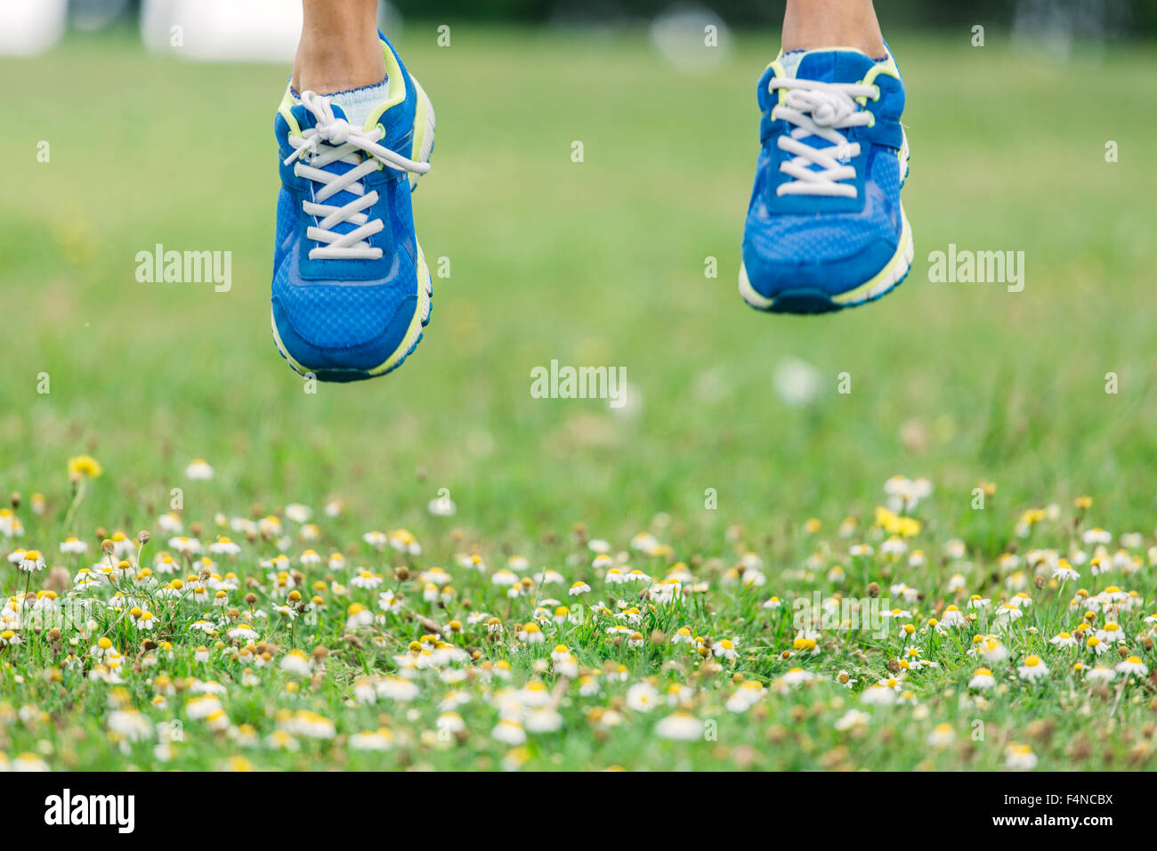 Jumping feet in trainers, midair Stock Photo Alamy