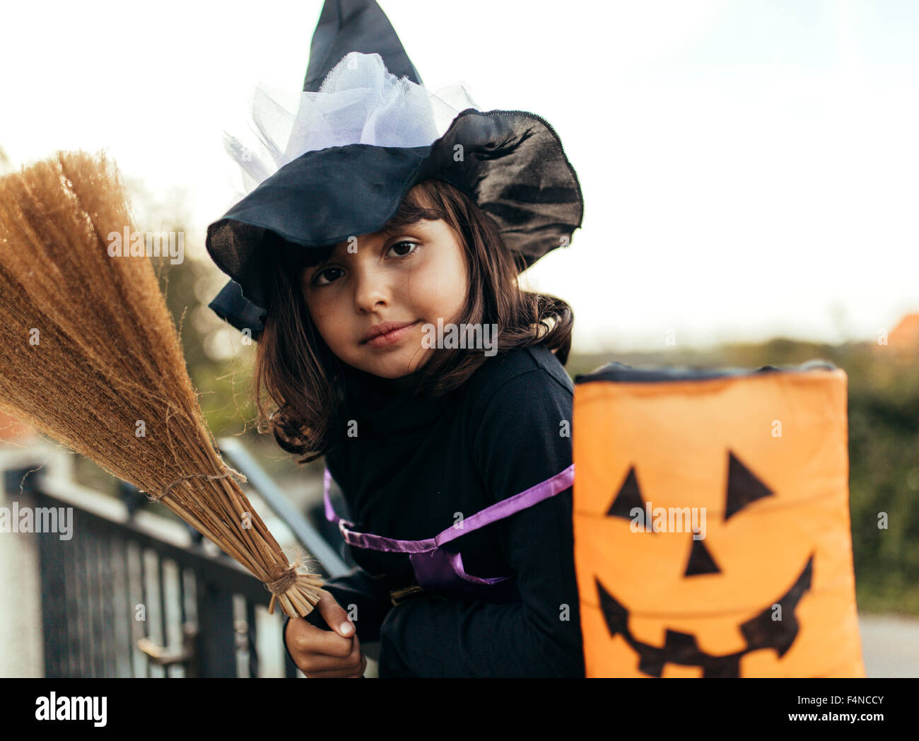 Portrait of little girl masquerade as a witch with halloween lantern ...