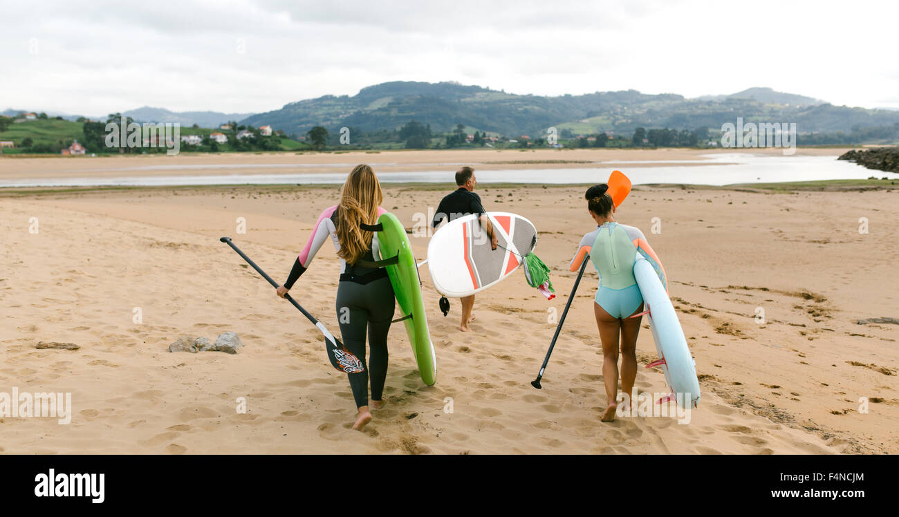 Spain, Asturias, Villaviciosa, three stand up paddler going to the water Stock Photo