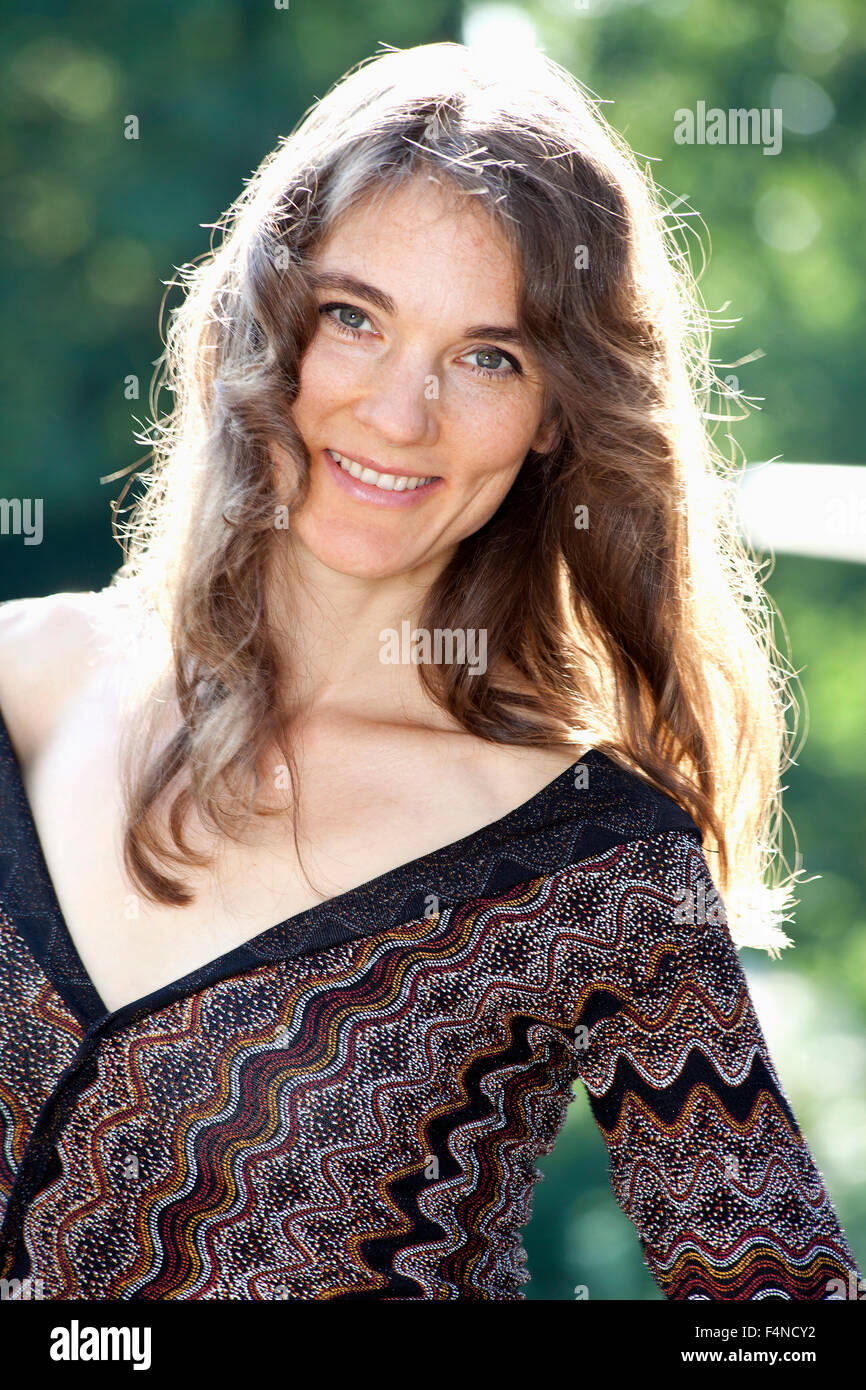 Portrait of smiling woman with long brown hair Stock Photo - Alamy