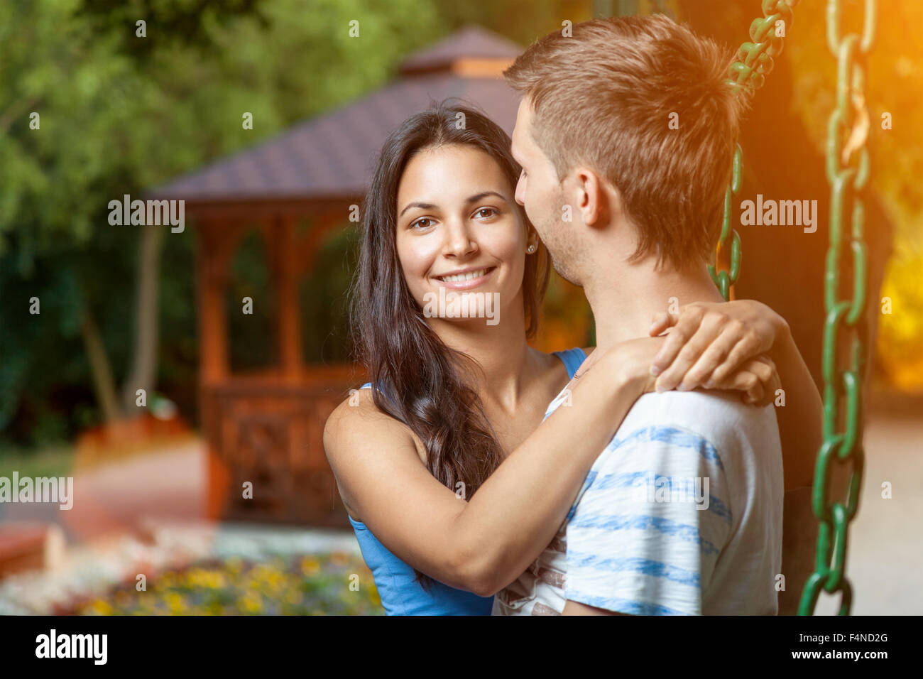 Happy young couple embracing in the park Stock Photo - Alamy