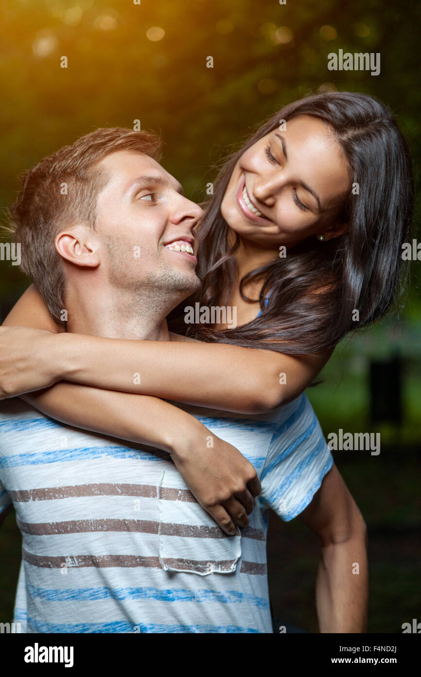 Happy young couple embracing in the park Stock Photo - Alamy
