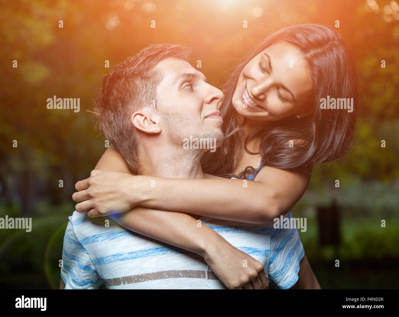Happy young couple embracing in the park Stock Photo - Alamy