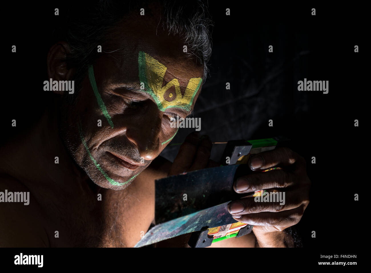 A Katakali artist is applying the make up of the character Jayantha Stock Photo