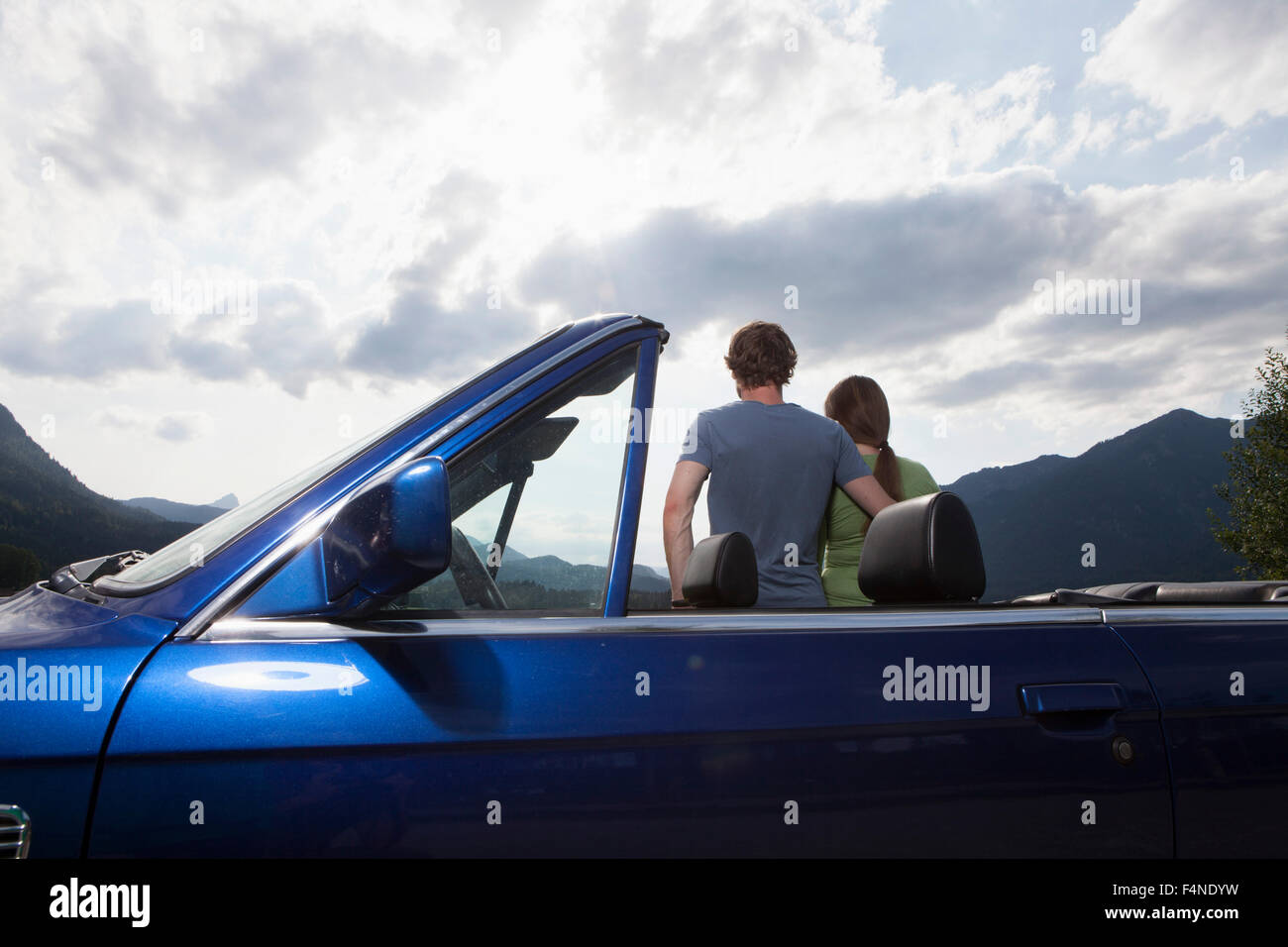 Germany, Bavaria, couple next to convertible looking at view Stock Photo