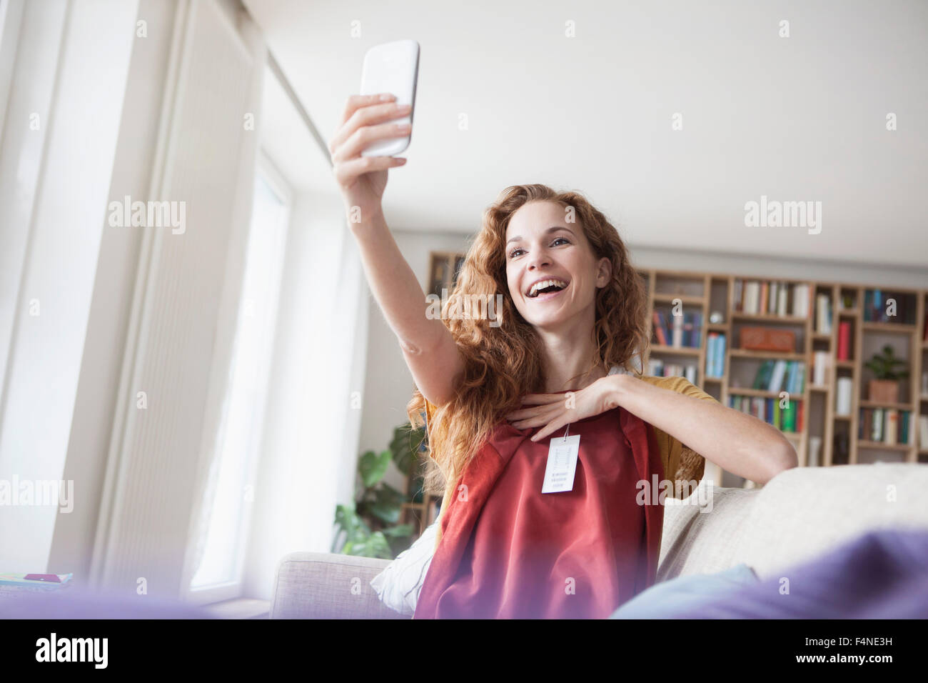Happy woman at home taking a selfie with new garment Stock Photo