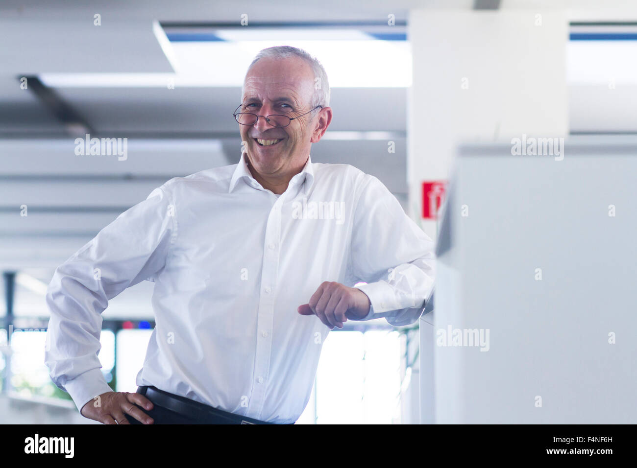 Smiling businessman in open space office Stock Photo - Alamy