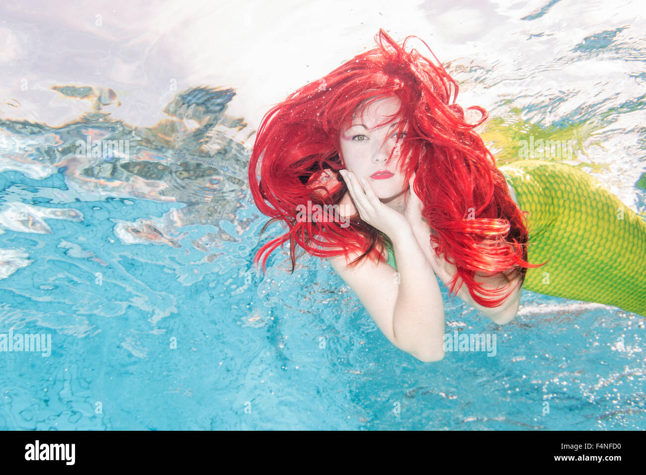 Young woman in the disguise of Arielle, the little mermaid, underwater Stock Photo