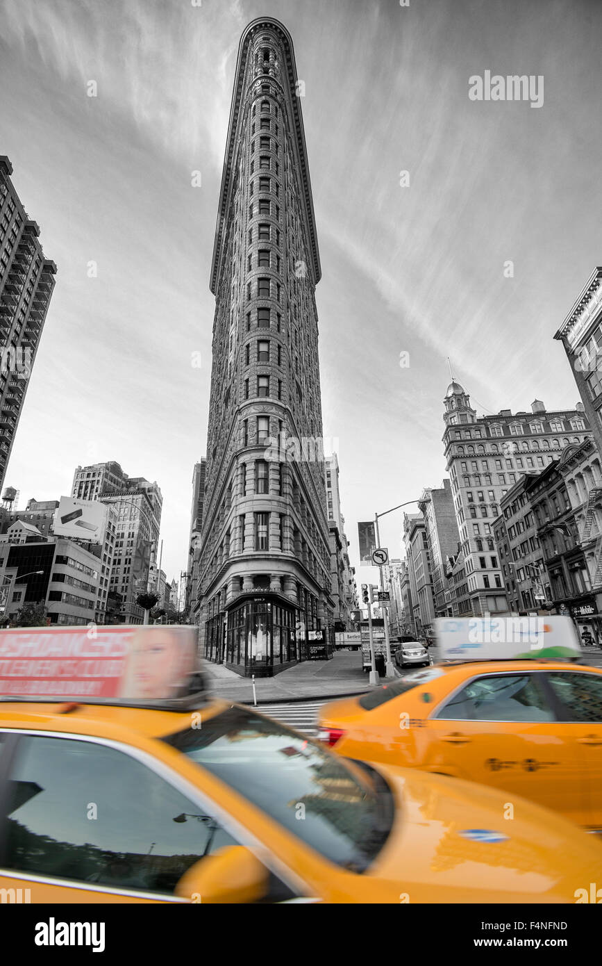 Selective colour image of the iconic Flatiron Building with two yellow cabs, Manhattan New York USA Stock Photo