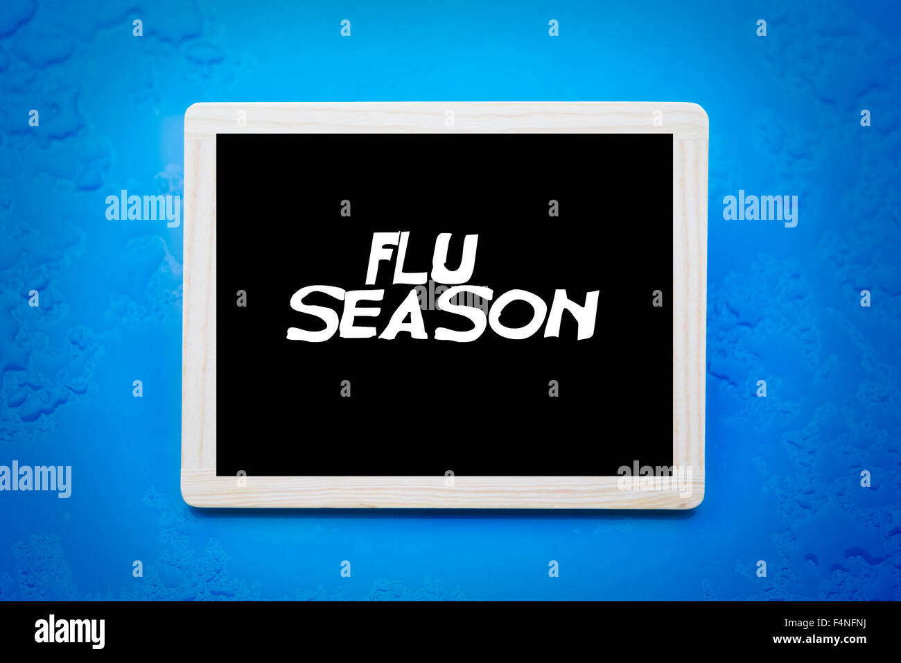 blackboard with words 'flu season' on blue wet background Stock Photo