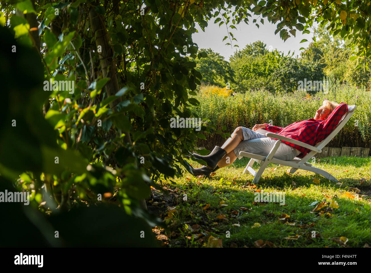 Senior woman relaxing in garden chair Stock Photo