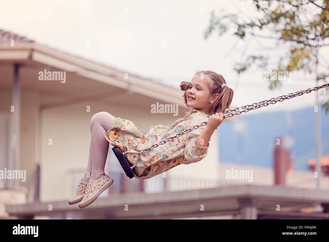 Happy little girl on a swing Stock Photo - Alamy