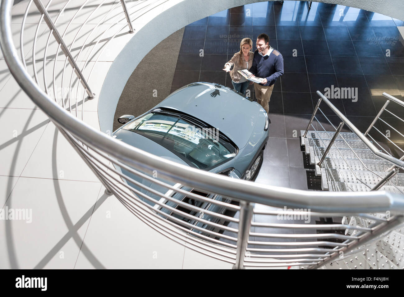 Couple looking at new car in showroom Stock Photo