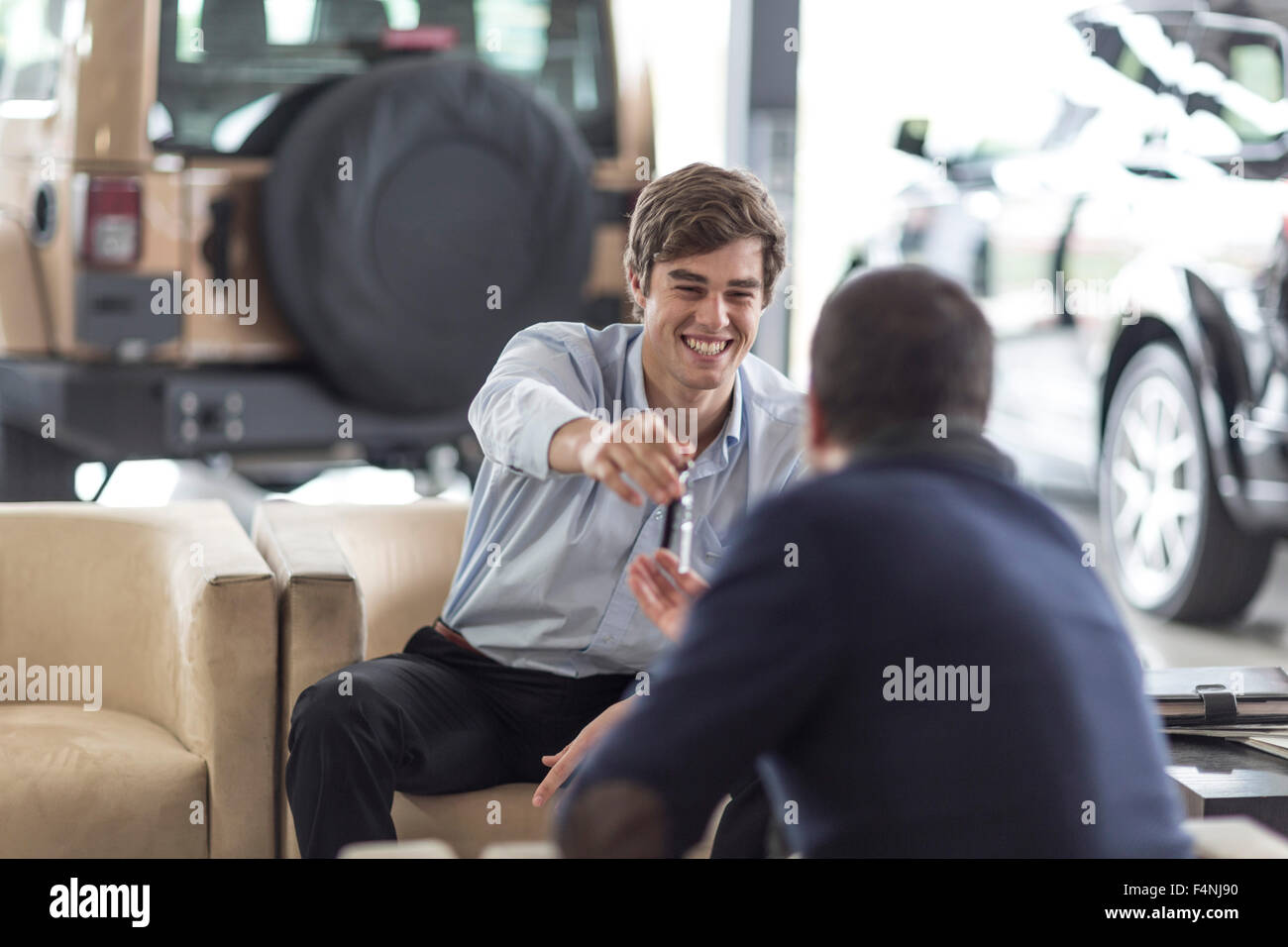 Car dealer giving key to client Stock Photo - Alamy