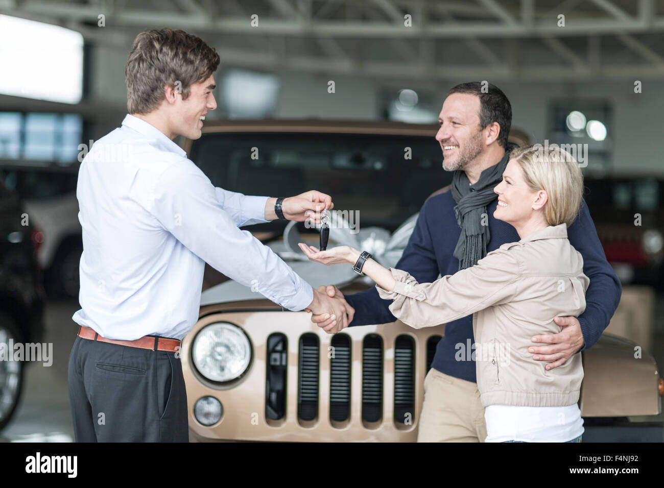 Car dealer giving key to client Stock Photo - Alamy